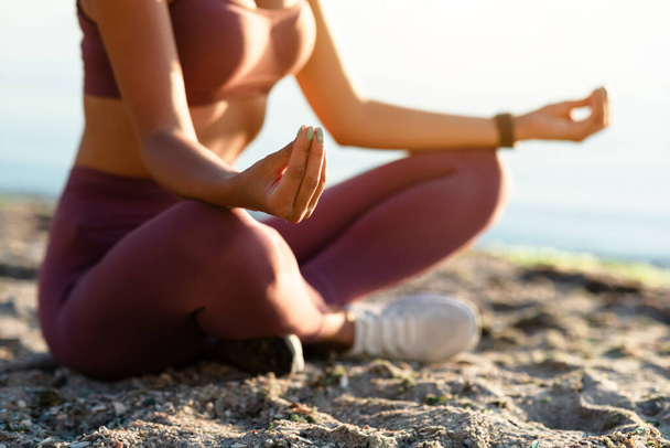 Vrouwelijke yogi zittend in lotushouding en mediterend - Foto, afbeelding