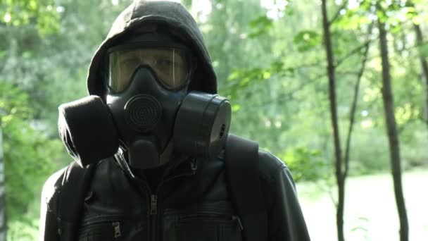 uomo in maschera antigas vicino serbatoio tossico. protezione delle armi chimiche, epidemia di virus - Filmati, video
