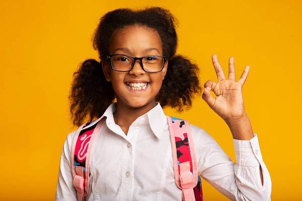 Africano American Schoolgirl Gesturing Ok Assine Sorrindo posando no estúdio
 - Foto, Imagem