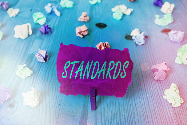 Text sign showing Standards. Conceptual photo something established by authority, custom, or general consent Colored crumpled rectangle shaped reminder paper light blue background. - Photo, Image