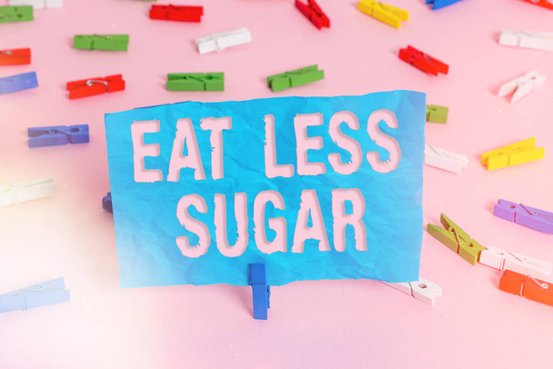 Käsitteellinen käsin kirjoittaminen osoittaa Syö vähemmän sokeria. Business valokuva esittelee vähentää sokerin saanti ja syö terveellistä ruokavaliota runsaasti elintarvikkeita Värilliset pyykkipoika paperit tyhjä muistutus vaaleanpunainen lattia toimisto. - Valokuva, kuva