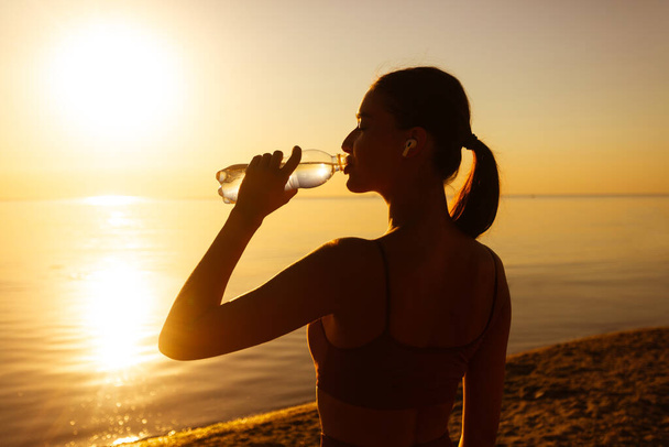 Hermosa atleta mujer beber agua después del ejercicio
 - Foto, Imagen