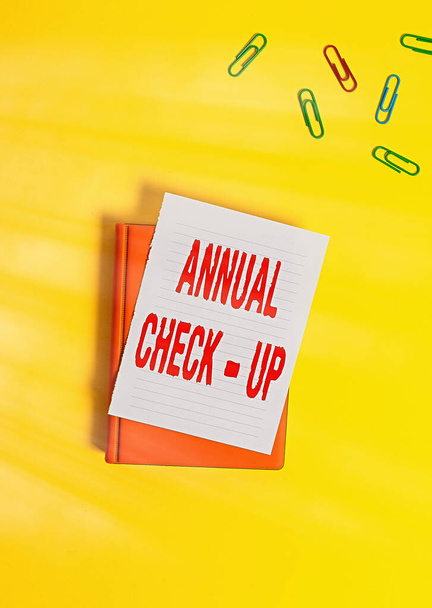 Text sign showing Annual Checkup. Conceptual photo yearly reproductive health visit with a health care provider Paper clips with blank papers for text messages. - Photo, Image