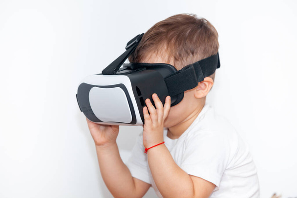 little boy with virtual reality glasses on a white background - Zdjęcie, obraz