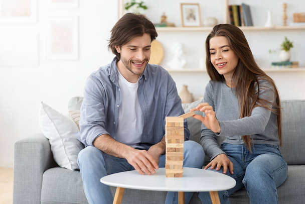 Man and woman playing Jenga at living room at home - Φωτογραφία, εικόνα