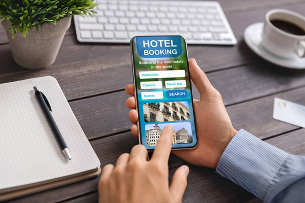 男性の手でオープンホテルの予約アプリケーションとスマートフォン - 写真・画像