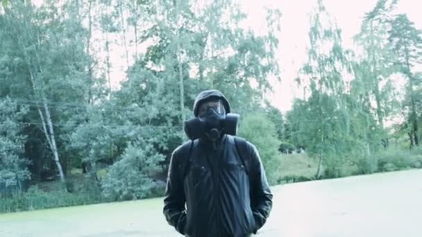 Mann mit Gasmaske in der Nähe eines Giftreservoirs. Chemiewaffenschutz, Virus-Epidemie - Filmmaterial, Video