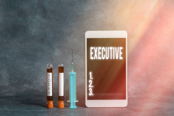 Text sign showing Executive. Conceptual photo belonging to the branch of government that is charged with powers Extracted blood sample vial with medical accessories ready for examination. - Photo, Image