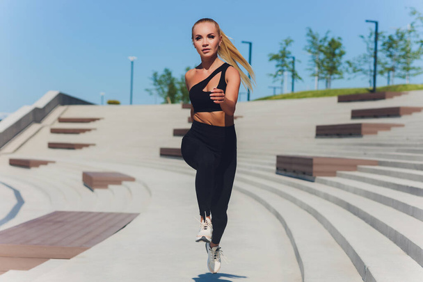 Running woman. Runner is jogging on sunrise. Female fitness model training outside in the city on a quay. Sport lifestyle. - Zdjęcie, obraz