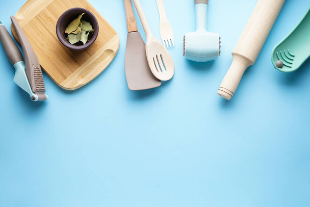 Vários utensílios de cozinha com espaço para texto sobre um fundo azul. Vista superior
. - Foto, Imagem