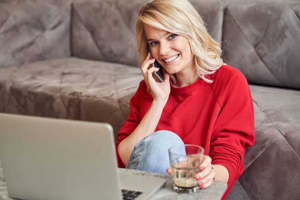Happy young woman relaxing at home and enjoying phone talk - Фото, зображення
