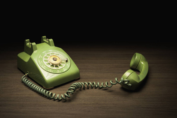 Teléfono de línea de plástico verde viejo sobre un fondo oscuro
 - Foto, Imagen