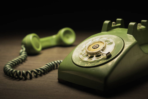 Old green plastic dial telephone on a dark background - Foto, Imagem