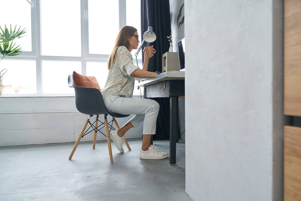 Elegant woman with coffee workin online at home - Фото, зображення