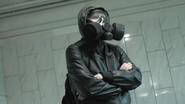 człowiek w masce gazowej w pobliżu ściany - ochrona przed bronią chemiczną, epidemia wirusa - Materiał filmowy, wideo