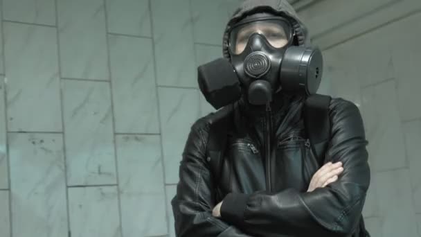 壁近くのガスマスクの男-化学兵器からの保護、ウイルスの流行 - 映像、動画