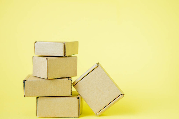 Cardboard boxes of various sizes on yellow background - Zdjęcie, obraz