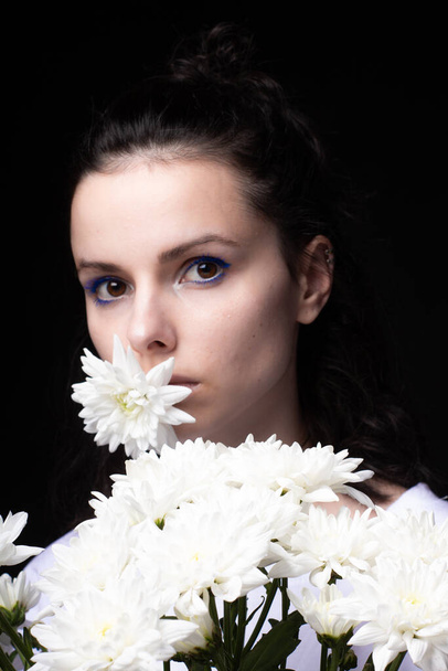 woman with a bouquet of flowers, black background - Foto, imagen