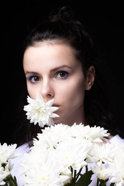 woman with a bouquet of flowers, black background - 写真・画像