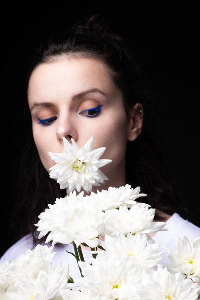 woman with white flowers on black background - 写真・画像
