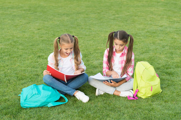 Schoolgirls little children school yard with books, interesting reading concept - Φωτογραφία, εικόνα