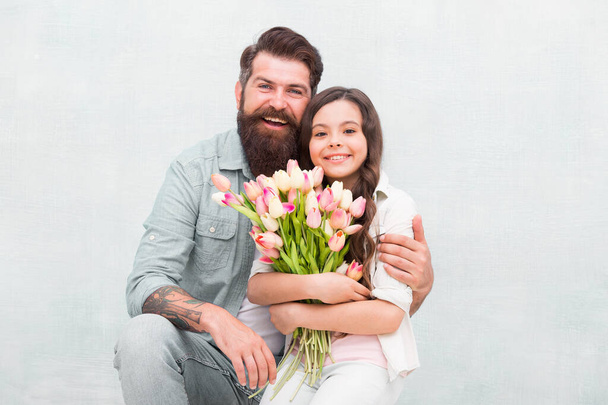 Happy childrens day. Happy family celebrate childrens day. Father embrace little daughter holding flowers. Bearded man and small child. Holiday celebration. International childrens day - Foto, imagen