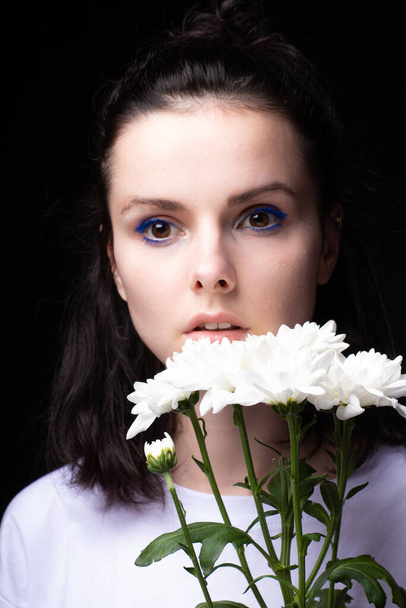 woman of model appearance, portrait with white flowers on black studio background - Fotó, kép