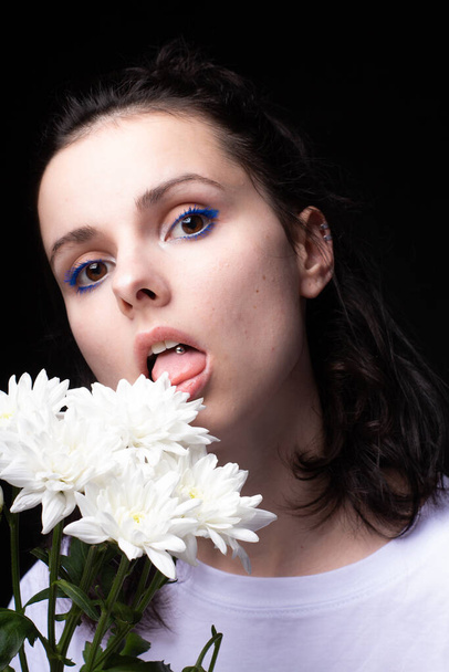 woman eating white flowers on black background - Fotografie, Obrázek