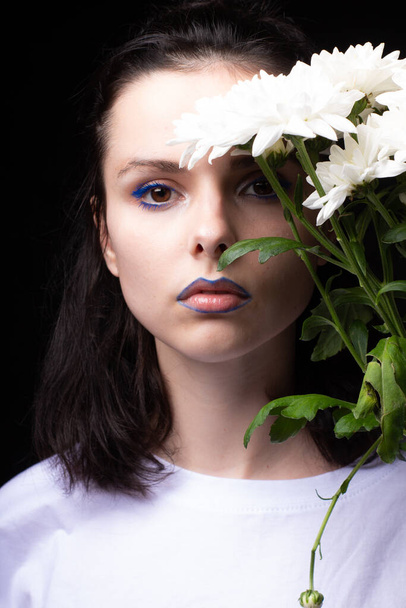 woman of model appearance, portrait with white flowers on black studio background - Фото, изображение