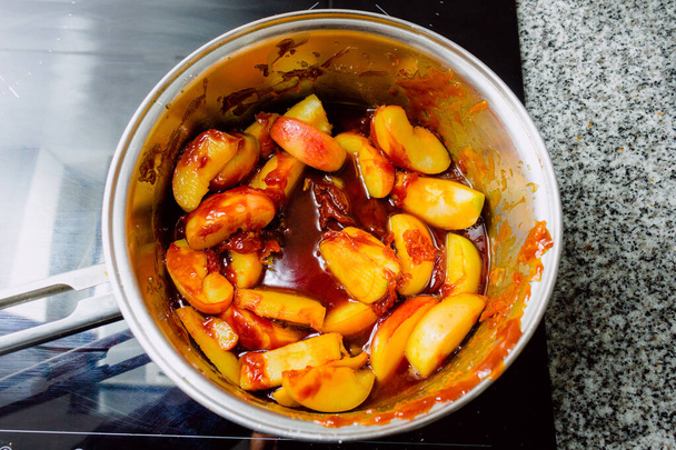 Veduta aerea di mele caramellate in una pentola su una pentola a induzione pronta a preparare una torta di mele - Foto, immagini