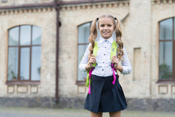 Bringing Excellence. child in uniform carry school bag. concept of education. development of childhood. happy girl has cute smile. happy preschool girl with backpack in school yard. back to school - Zdjęcie, obraz