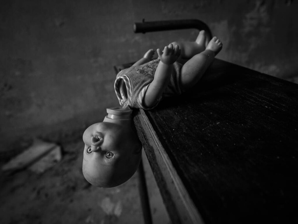 Terk edilmiş bir psikiyatri tesisinin odalarında terk edilmiş eski bir oyuncak bebek. - Fotoğraf, Görsel