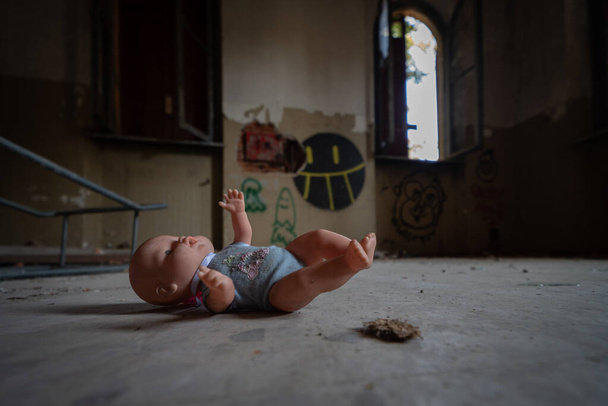 Eine Vintage-Puppe, die in den Räumen einer verlassenen psychiatrischen Einrichtung ausgesetzt wurde, Urbex-Bild - Foto, Bild