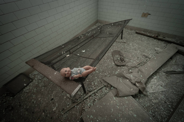 Una bambola vintage abbandonata nelle stanze di una struttura psichiatrica abbandonata, immagine urbex - Foto, immagini