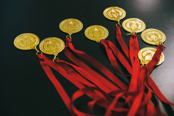 Medallas de oro olímpicas en una mesa negra para recompensar a los ganadores
. - Foto, Imagen