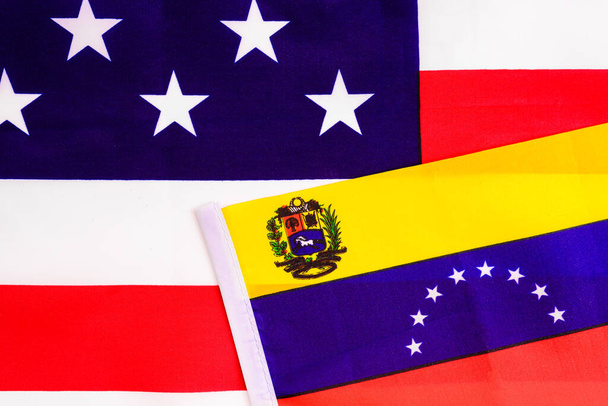 Σημαία της Βενεζουέλας στην αμερικανική εθνική σημαία, δύο χώρες με σύγκρουση μεταξύ τους. - Φωτογραφία, εικόνα