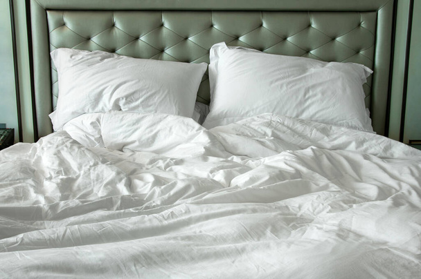 Mocskos fehér ágynemű és párna reggel a szobában - Fotó, kép