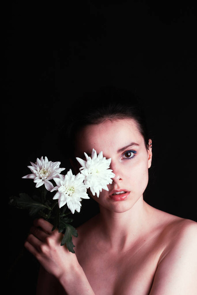 beautiful girl with chrysanthemum, black background - Фото, изображение