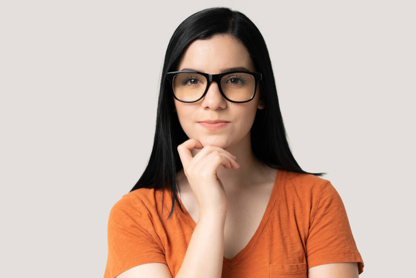 Closeup of confident pretty young woman in eyeglasses against gray background - Photo, Image