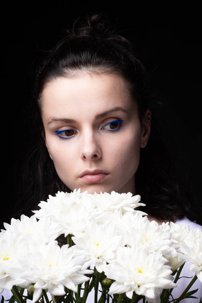 woman with a bouquet of chrysanthemums on a black background - Photo, image