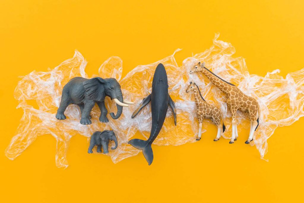 Animals is entangled in a plastic bag. Plastic animal concept. Yellow background. Environmental pollution problem. - Foto, Bild