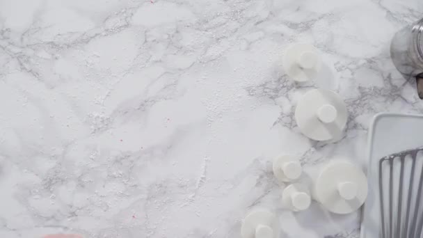 Ritaglio di fiocchi di neve con tagliabiscotti di fondente bianco su un bancone di marmo. - Filmati, video