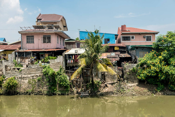Uma favela ou área de squatter ao longo do rio Zapote que faz fronteira com Metro Manila e Cavite. Desrespeito das leis de zoneamento perto das margens dos rios
. - Foto, Imagem