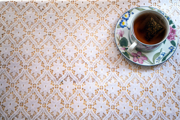 šálek čaje a krajka ubrus scéna - Fotografie, Obrázek