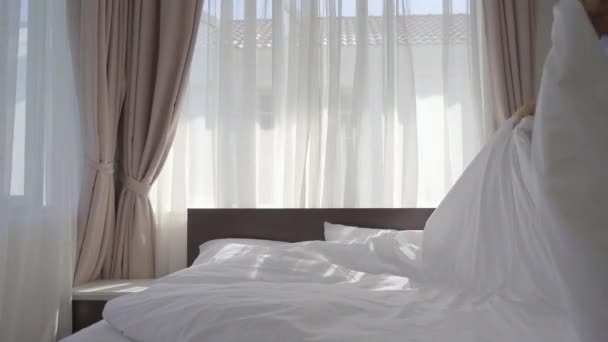 A young man changes bedding on the bed - Video, Çekim