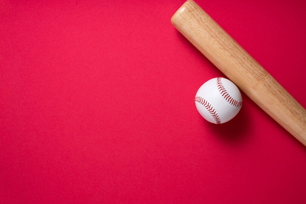 baseball and baseball bat on red table background, close up - Фото, изображение