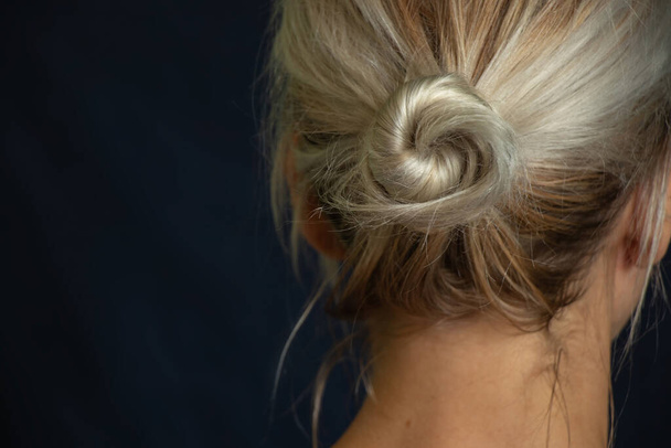 μαλλιά ενός νεαρού κοριτσιού μαζεμένα σε ένα κουλούρι πίσω όψη - Φωτογραφία, εικόνα
