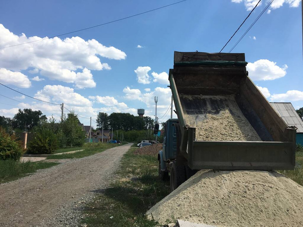 A truck brought sand for the construction site. Bulk cargo delivery. High quality photo - Photo, Image