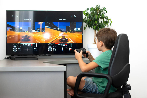 Ragazzo adolescente online gioca un gioco per computer con le cuffie e un joystick, console di gioco. - Foto, immagini