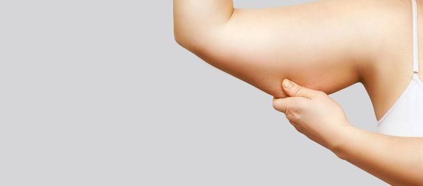 Young woman pinch fat arm. Hand pinching body. Female person showing - Photo, image